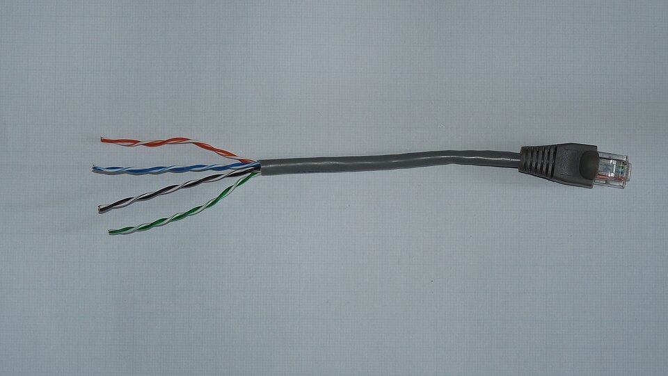 An Ethernet twisted pair cable with an RJ-45 connector, showing the four pairs of color-coded twisted copper wires inside the jacket